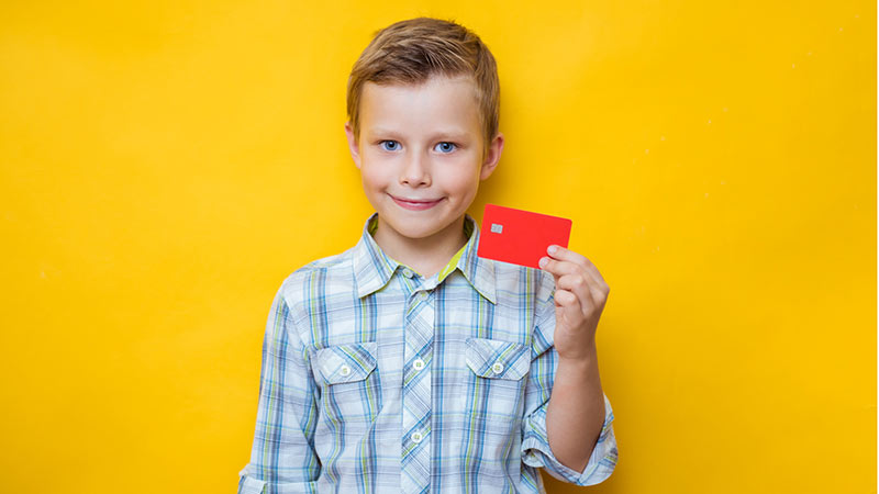 Jeune garçon tenant uyne carte de banque